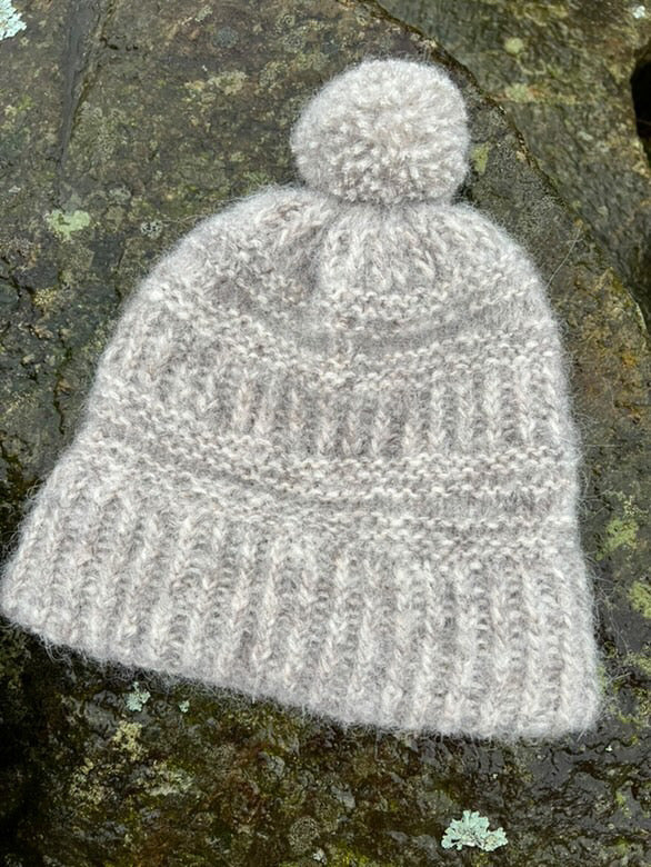 Grå Coffee Beanie med dusk på en sten · jævne indtagninger giver en rund top