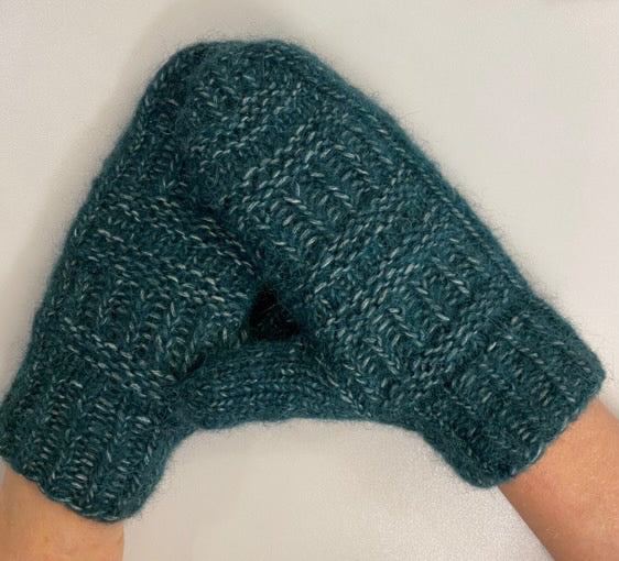 Blågrønne Coffee Mittens på hænderne, set fra siden · tommelfingeren strikkes til sidst