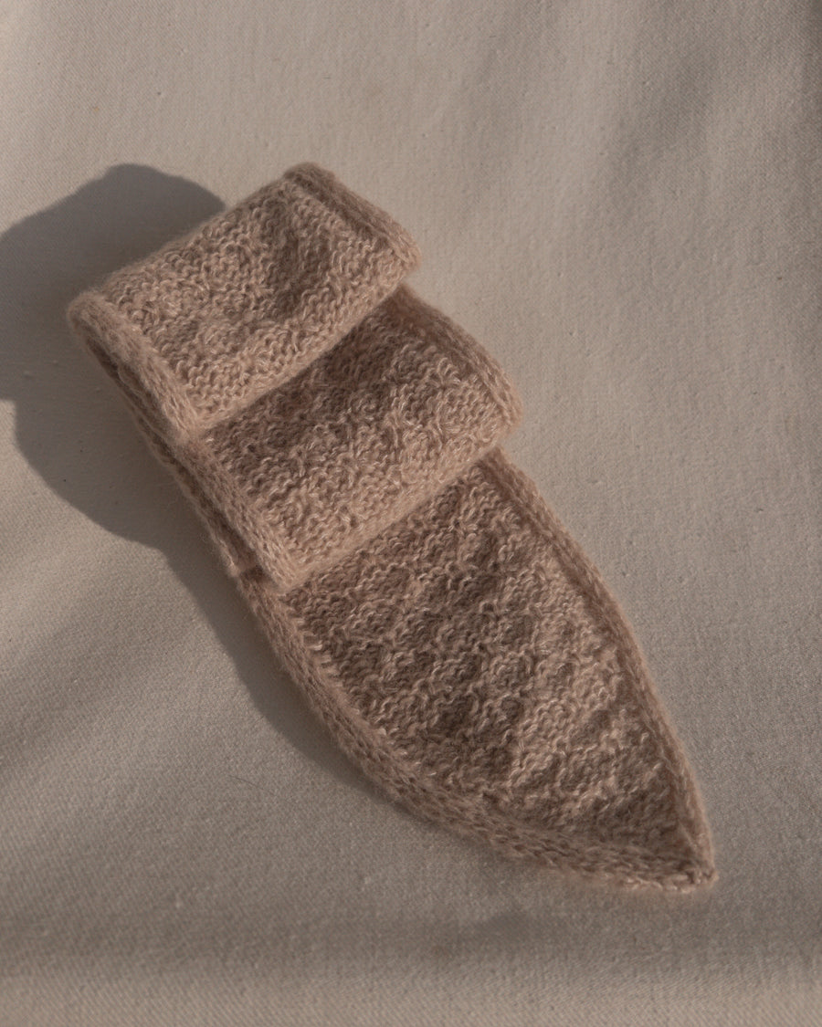 Rosabeige Granola Scarf foldet sammen på lys stof · dobbeltstrikket kant med udtagninger