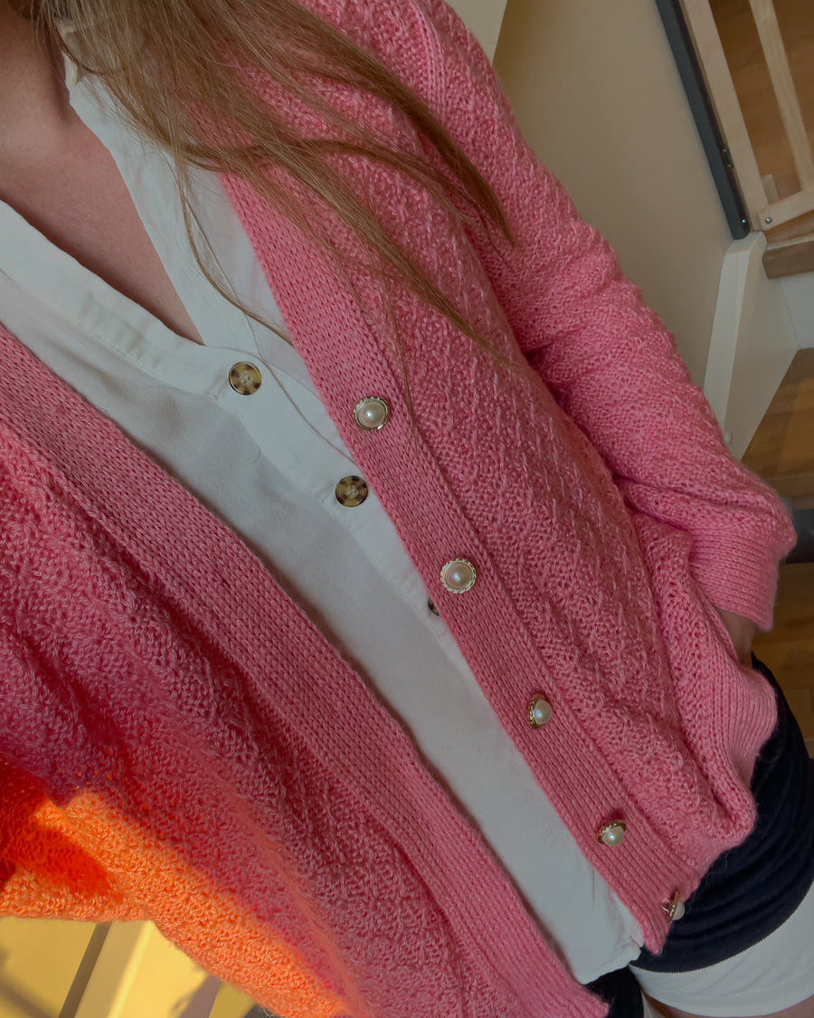 Lyserød Granola Cardigan over hvid bluse · dobbeltstrikket knapkant