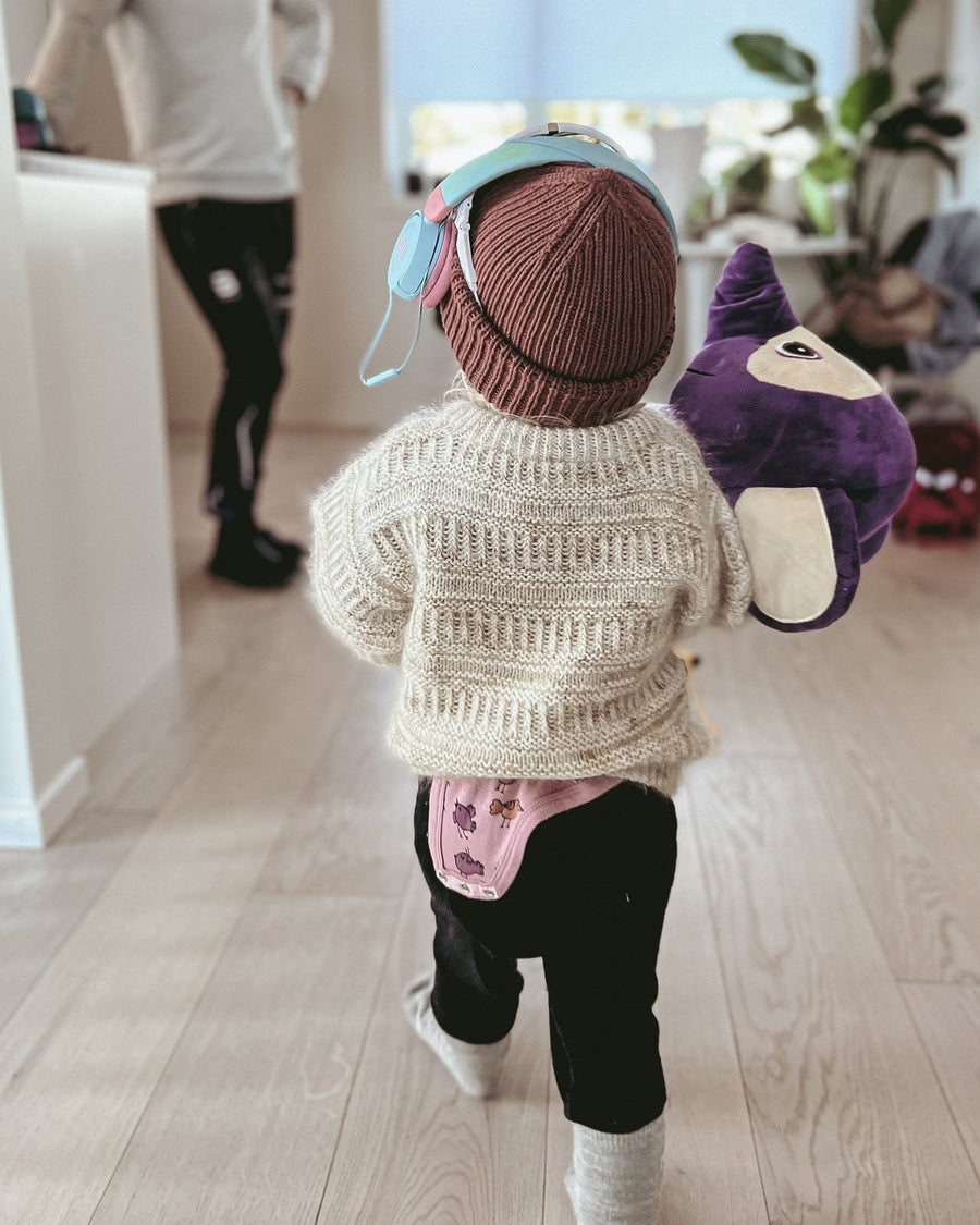 Barn på vej indendørs i Coffee Sweater Mini, set bagfra · størrelser fra 1 til 14 år