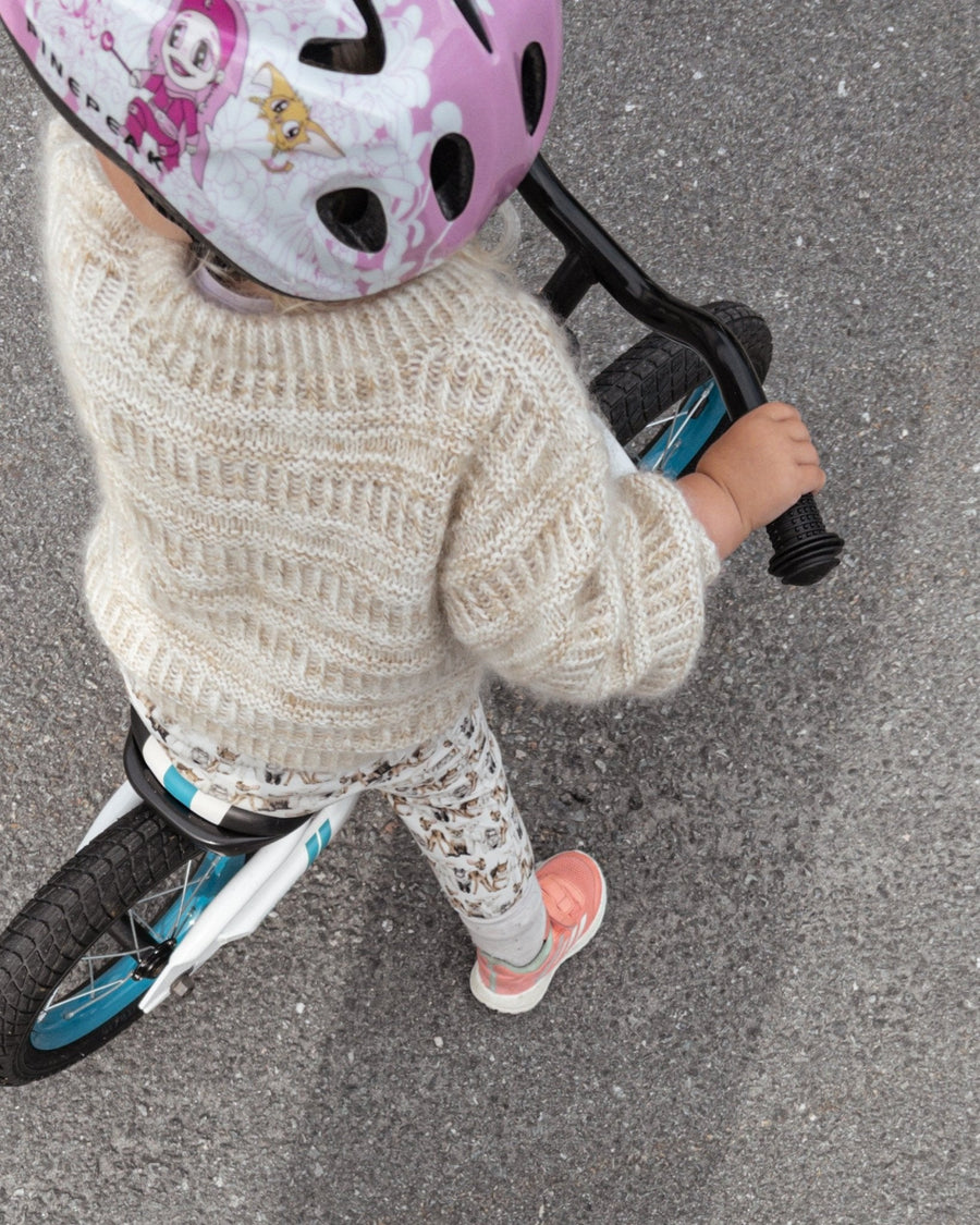 Coffee Sweater Mini på barn på løbecykel, set oppefra · tættere rib giver frie håndled