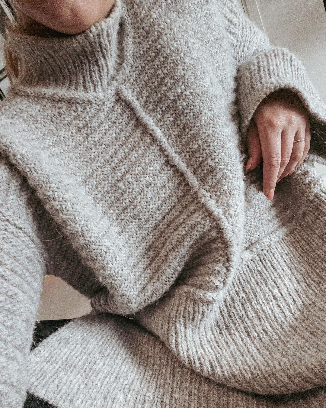 Grå Dawn Sweater med høj hals og i-cord midt foran, set på nært hold · oversize og løstsiddende