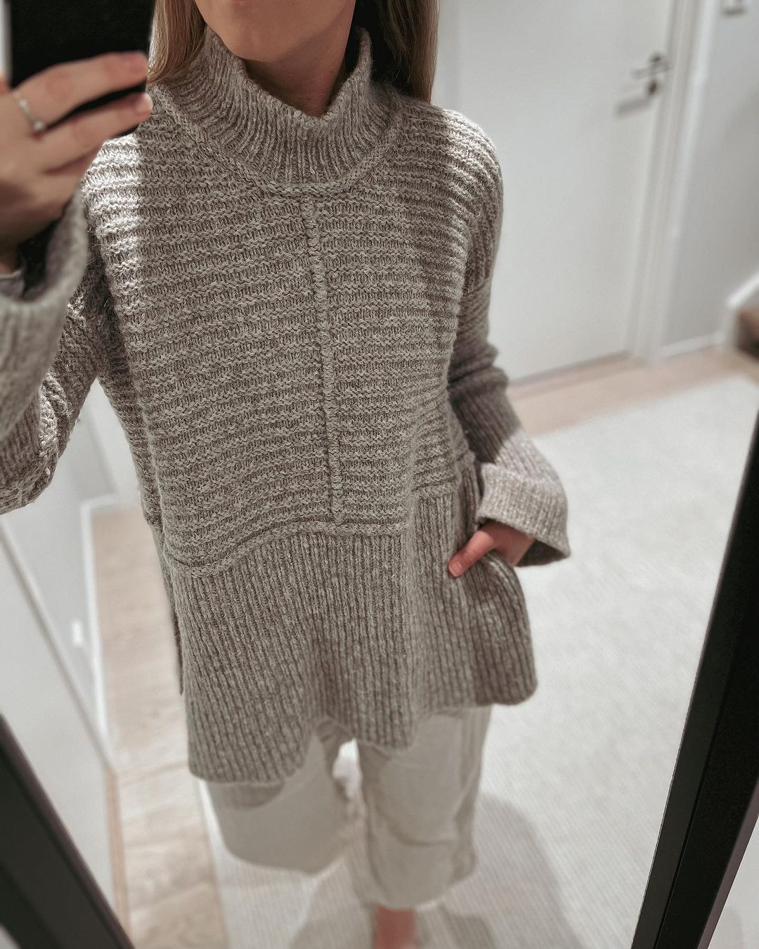 Spejlbillede af brungrå Dawn Sweater med i-cord midt foran og rib forneden · høj slids i siderne