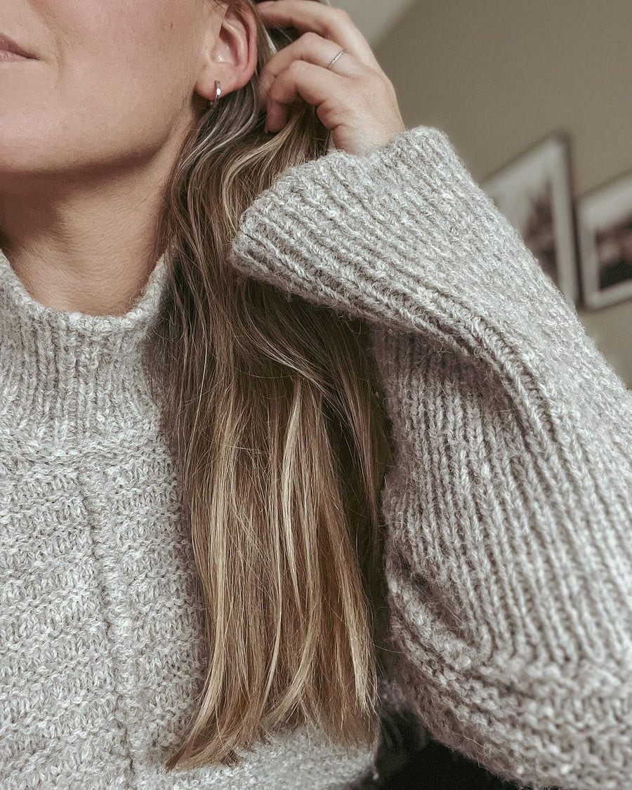 Nærbillede af ribbet ærme og høj hals på grå Dawn Sweater · ca. 25 til 30 cm bevægelsesvidde i str. 1 til 6