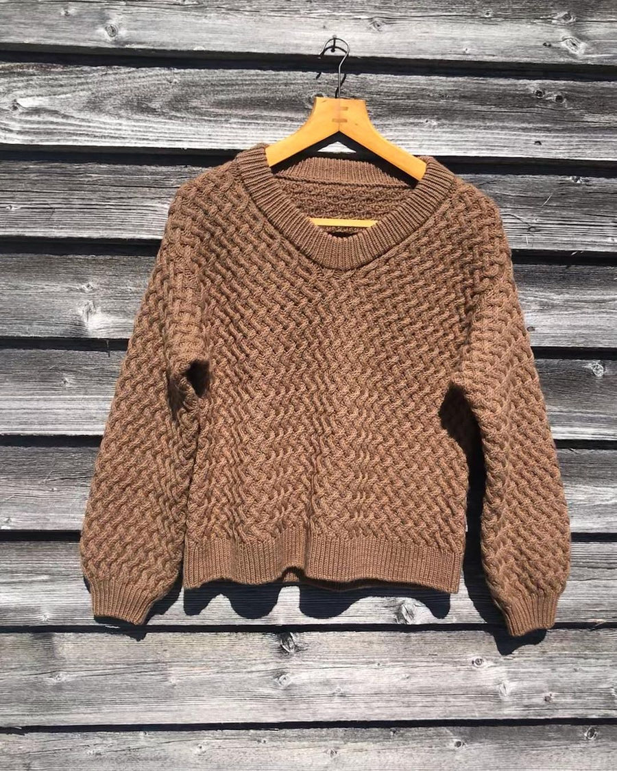Brun Lounge Sweater på bøjle mod en trævæg · lige i formen, let oversize