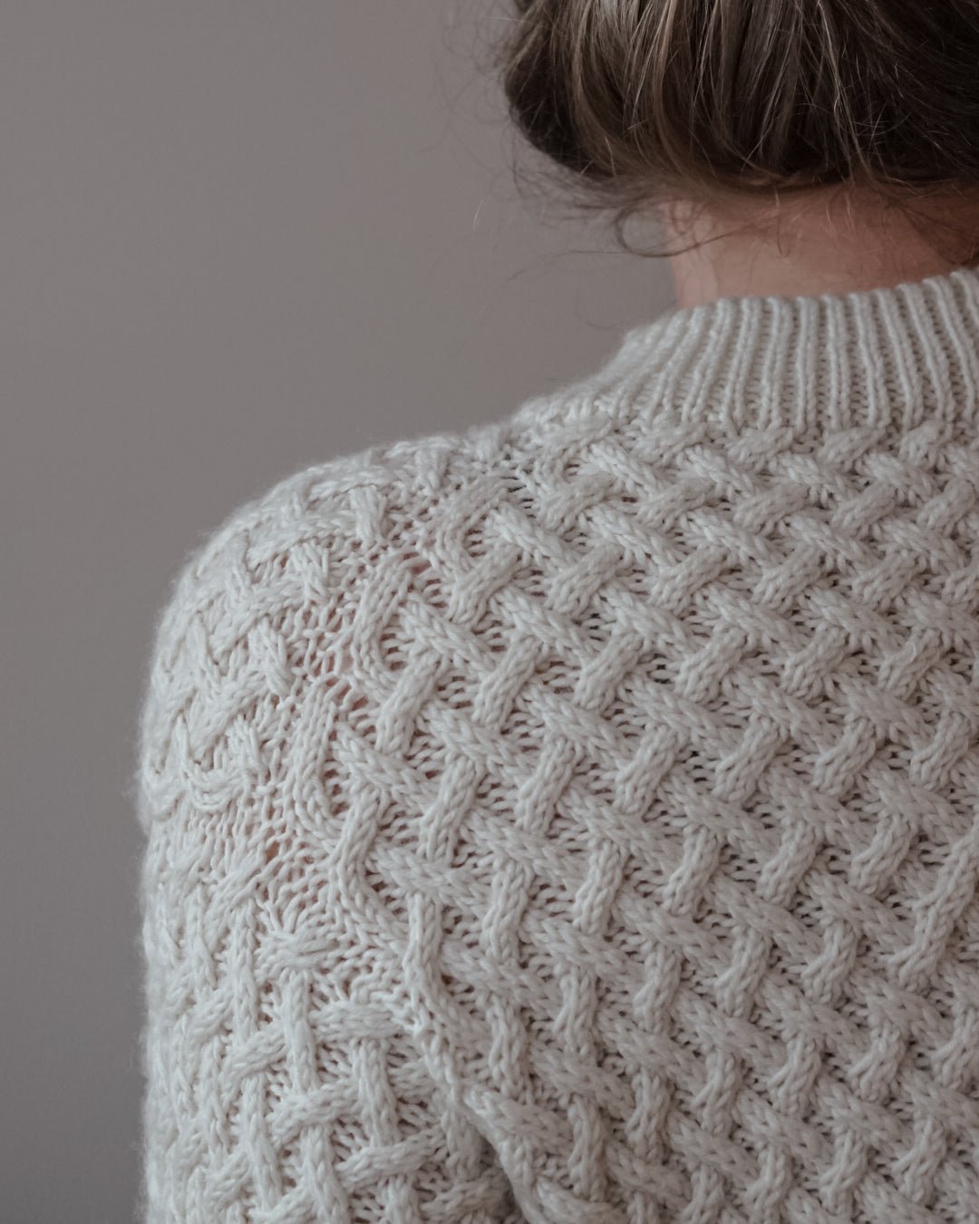 Skulder og ærme på cremehvid Lounge Sweater · bagstykket strikkes frem og tilbage med skulderudtagninger